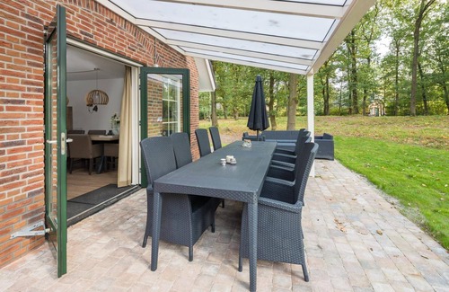 Hooghalen House | Wellness bungalow with whirlpool, sauna, sunshower, 3 bedrooms, and a covered terrace with lounge set.