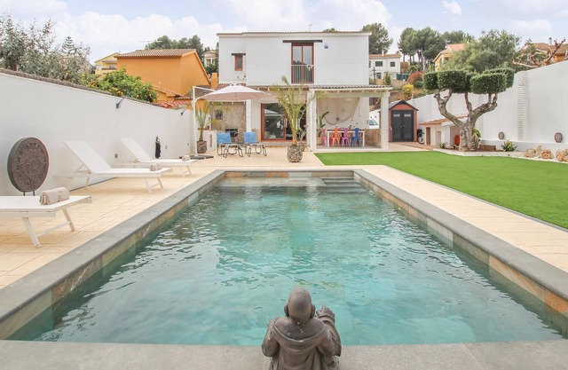 A large cottage with bright interior and private outdoor pool, next to a covered terrace.
