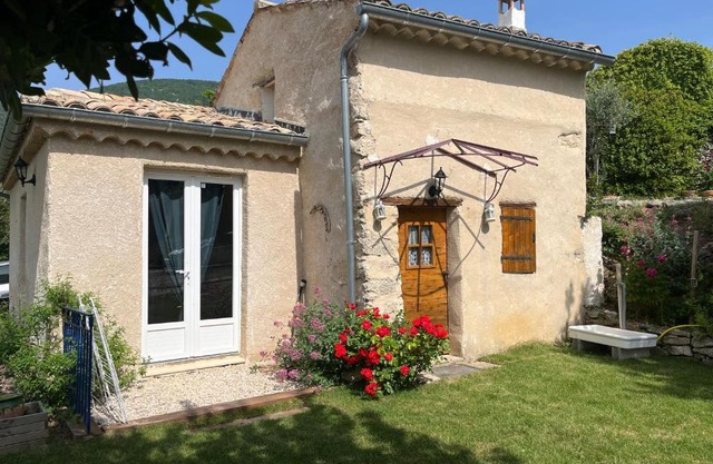 Cabanon entouré de montagnes et d'oliviers
