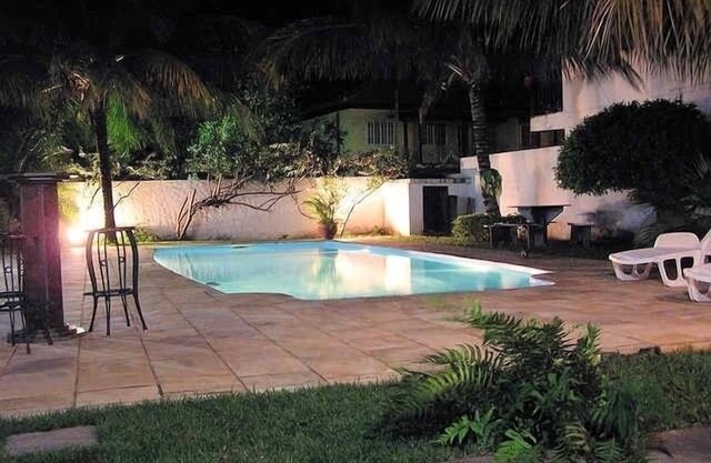 Colonial house, big swimming pool at sunset bay