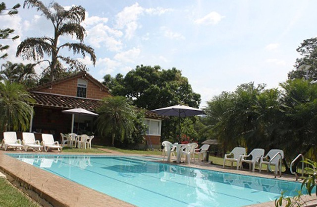 Country estate with a pool, a view of the mountains, and green areas