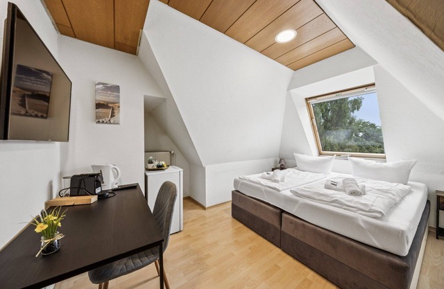 Cozy double room, flat-screen TV, and modern bathroom with shower. Ideal for couples and short stays – enjoy a relaxed atmosphere with warm wood accents and coastal charm.