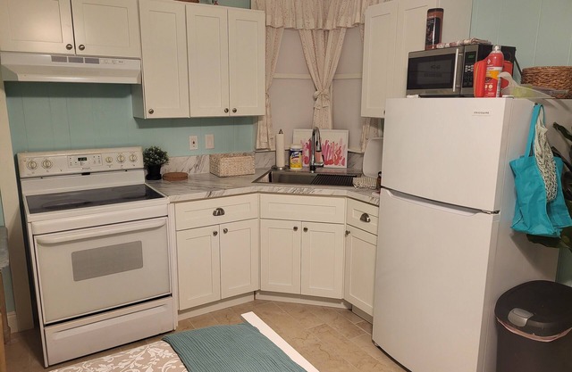 Cozy XL room with kitchenette, dining table, couch, and smart tv, shared bath