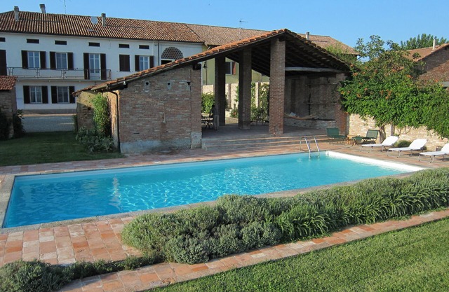 Farmhouse with swimming pool surrounded by greenery