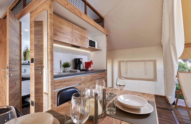 Glamping tent equipped with living room, kitchen and bathroom.