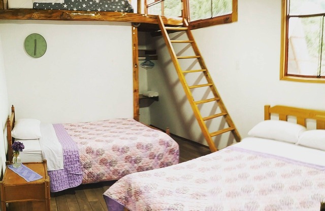 Habitacion tipo cabaña con acabados en madera, terraza con vista hacia la montaña