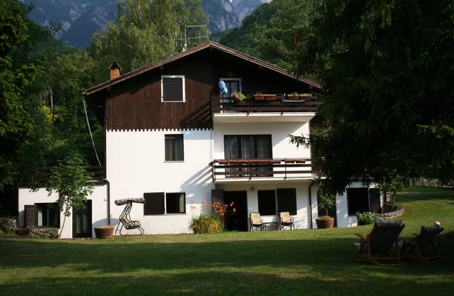 House with large garden surrounded by greenery
