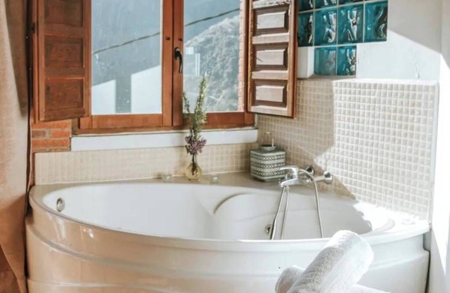 Jacuzzi in bedroom with mountain views and fireplace