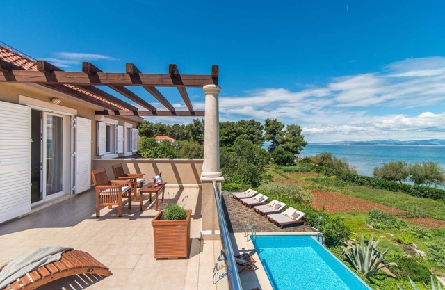 Luxury 6-BR Waterfront Villa with Infinity Pool and direct access to a pebble beach