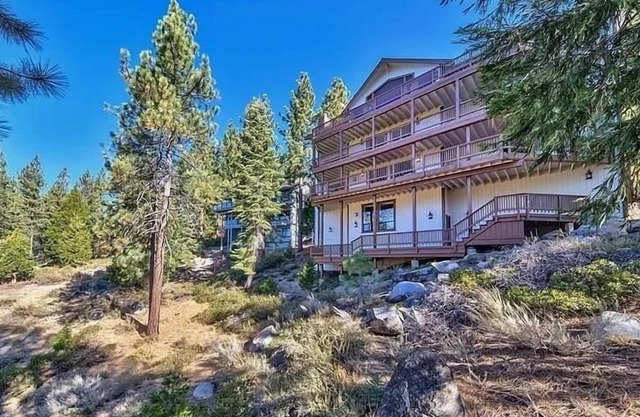 Luxury lake-view home with spacious deck, sauna, golf room, & wet bar