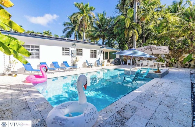 Modern Hollywood Beach villa with a private heated saltwater pool, hot tub, and spacious family-friendly layout. Just 1 mile from the ocean & Broadwalk, featuring a full kitchen, open living areas, and tropical outdoor lounge spaces.