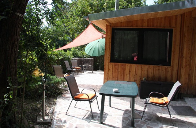 Modernly furnished bungalow with fireplace, surrounded by greenery.