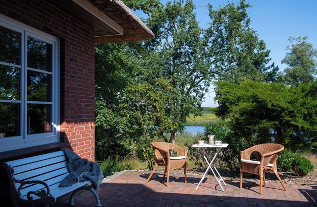 Right on the water: large thatched house with garden and fireplace