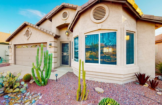 Southwestern home with colorful patio, sparkling pool, grill & dart board