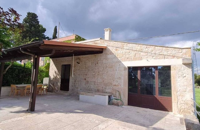 Stone farmhouse surrounded by greenery with shared pool