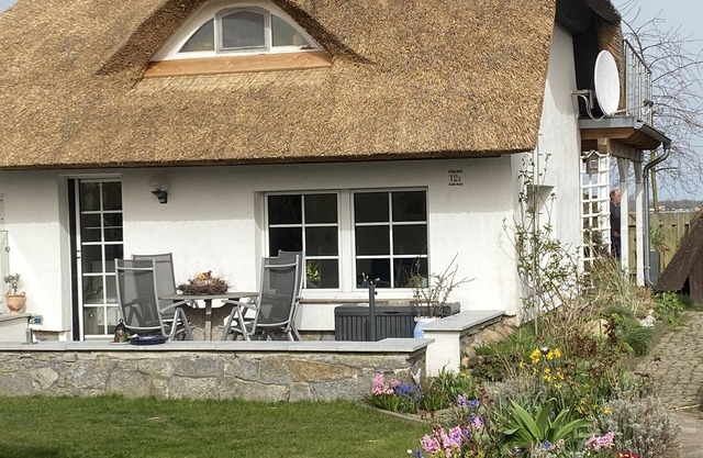 Thatched-roof holiday home with water view, garden and fireplace