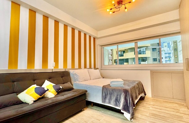 Yellow studio with air conditioning and garage next to shopping center.