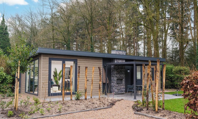 Lieren House | Enjoy a luxury holiday home in the wooded nature of the Veluwe, featuring modern amenities, air conditioning, and a stylish pergola with electric fireplace for optimal comfort.