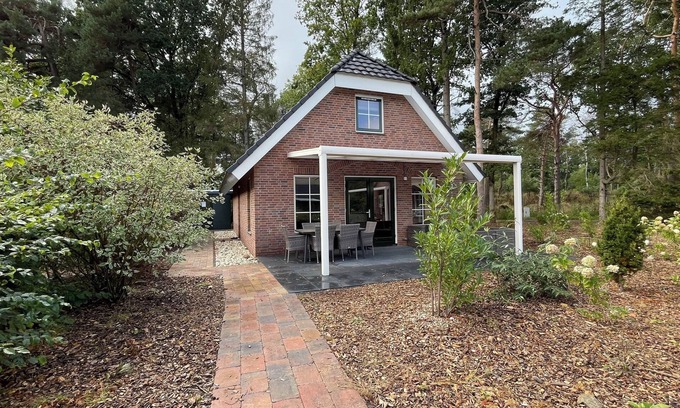 Hooghalen House | Wellness bungalow with whirlpool, sauna, sunshower, 3 bedrooms, and a covered terrace with lounge set.